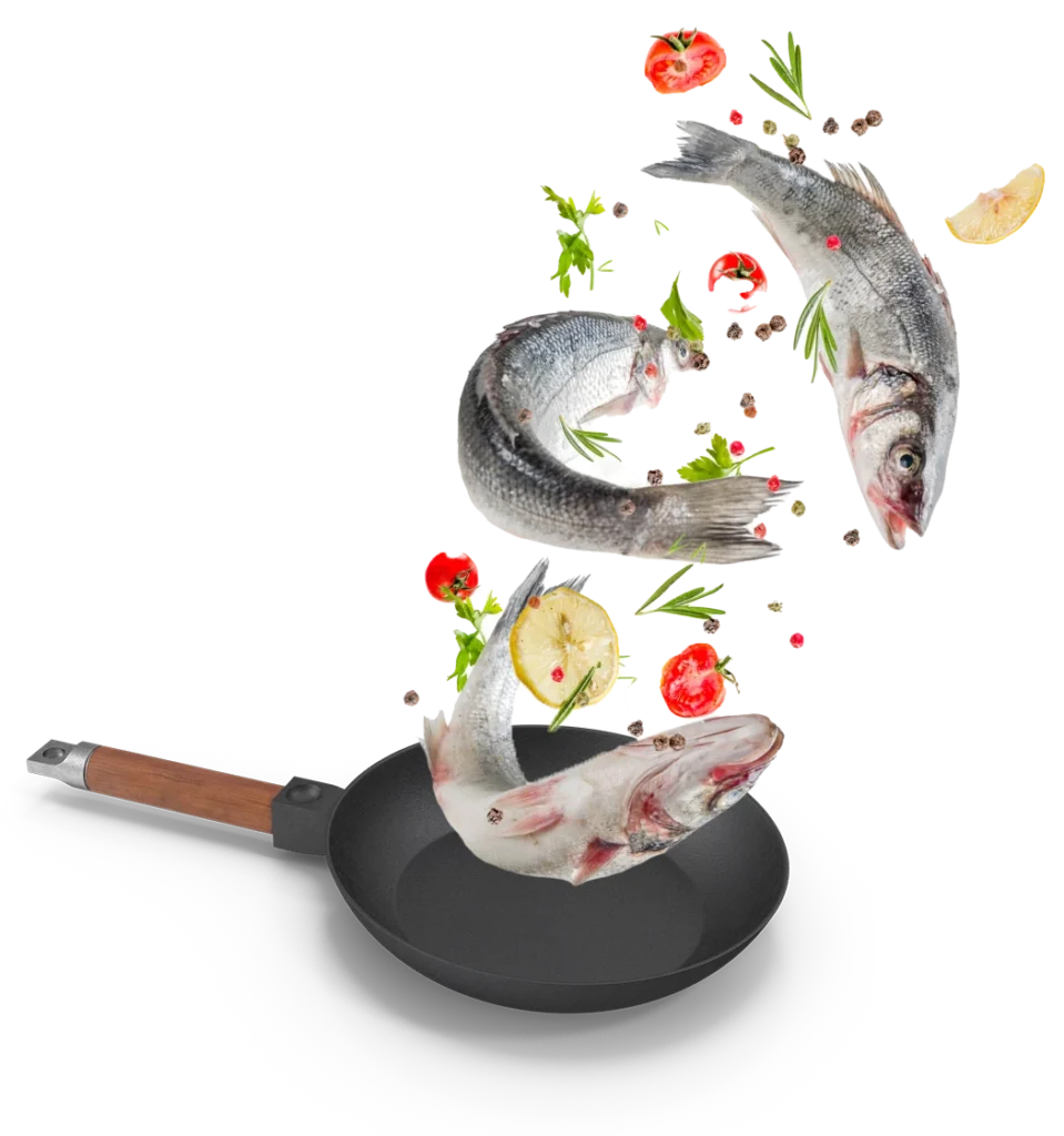 Peces frescos acompañados de limón, tomates y hierbas flotando sobre una sartén lista para cocinar