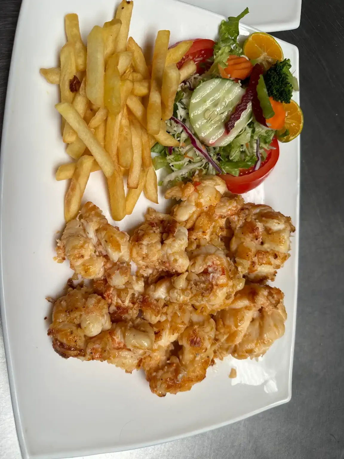 Langosta al ajillo con papas fritas y ensalada