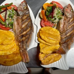 Pescado frito entero con patacones y ensalada, utilizado en el baner del contáctenos